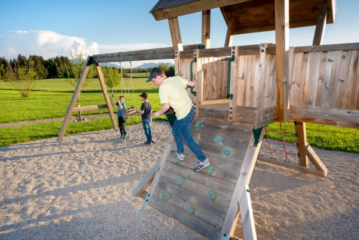 Junge hüpft vom Kletterhaus