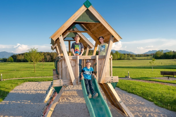 Kinder auf einem Rutschenhaus im Sandkasten