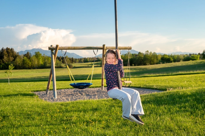 Kind auf einer Seilbahn am Spielplatz
